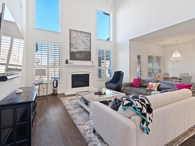 living room featuring a towering ceiling and dark wood-type flooring