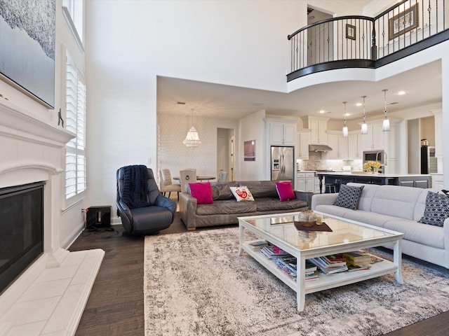 living room with a fireplace, dark hardwood / wood-style floors, and a high ceiling