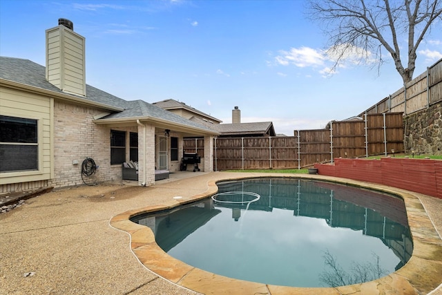 view of pool with area for grilling, a patio area, a fenced backyard, and a fenced in pool