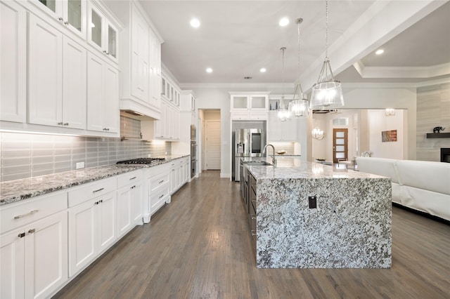 kitchen featuring white cabinetry, hanging light fixtures, a large island, appliances with stainless steel finishes, and glass insert cabinets