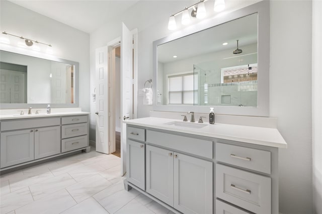 full bathroom featuring marble finish floor, a shower stall, two vanities, and a sink