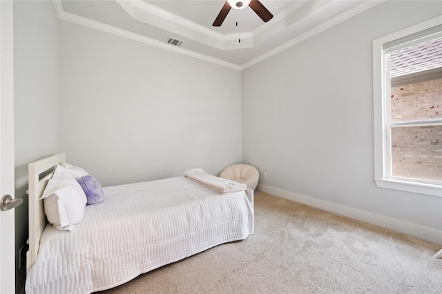 bedroom featuring a tray ceiling, crown molding, visible vents, carpet flooring, and baseboards