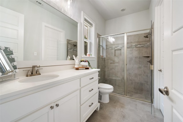 full bathroom featuring a stall shower, visible vents, toilet, tile patterned floors, and vanity