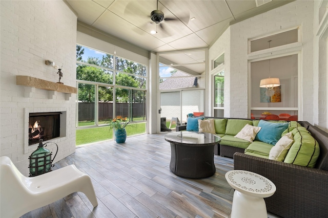 view of patio with fence, an outdoor living space with a fireplace, and ceiling fan