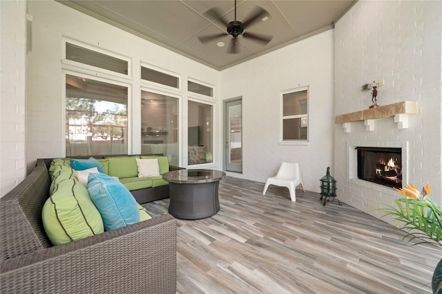 wooden deck featuring an outdoor living space with a fireplace and a ceiling fan