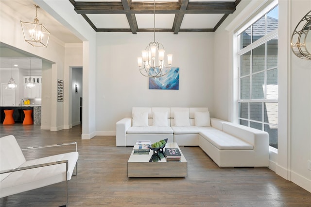 living area featuring a healthy amount of sunlight, wood finished floors, and an inviting chandelier