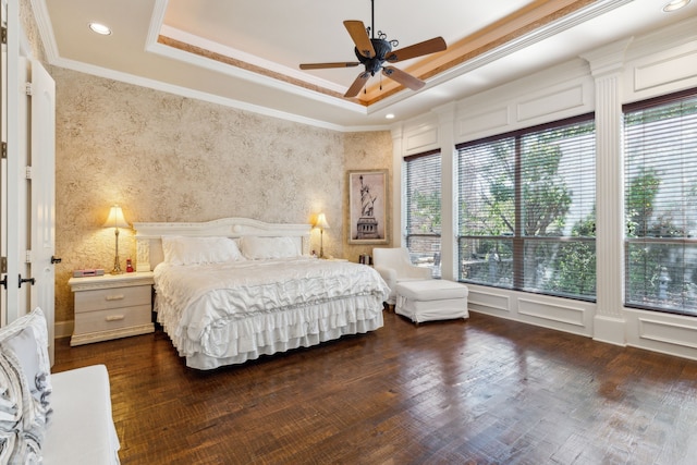 bedroom with crown molding, ceiling fan, dark hardwood / wood-style floors, and a raised ceiling