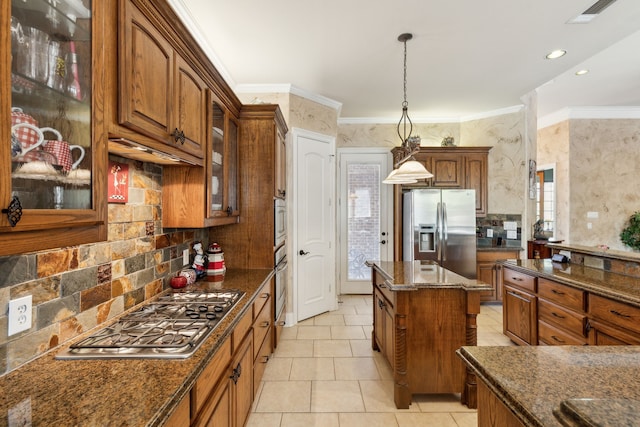 kitchen featuring tasteful backsplash, dark stone counters, hanging light fixtures, stainless steel appliances, and crown molding