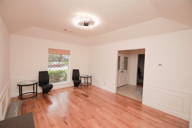 living area featuring lofted ceiling and hardwood / wood-style floors