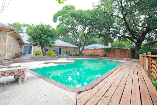 view of pool with a diving board and a patio area