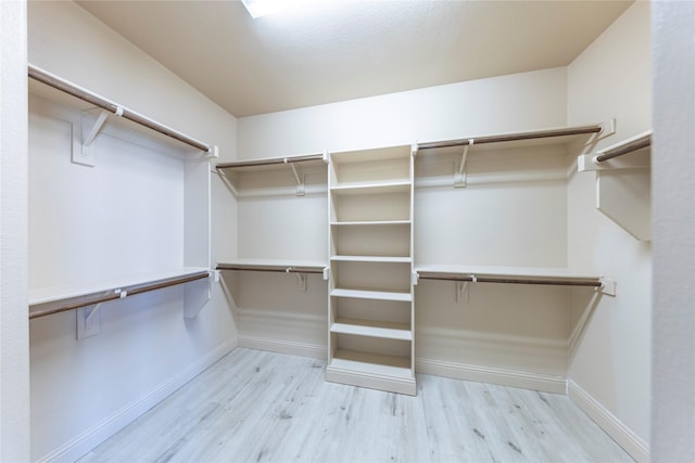 walk in closet with light wood-type flooring