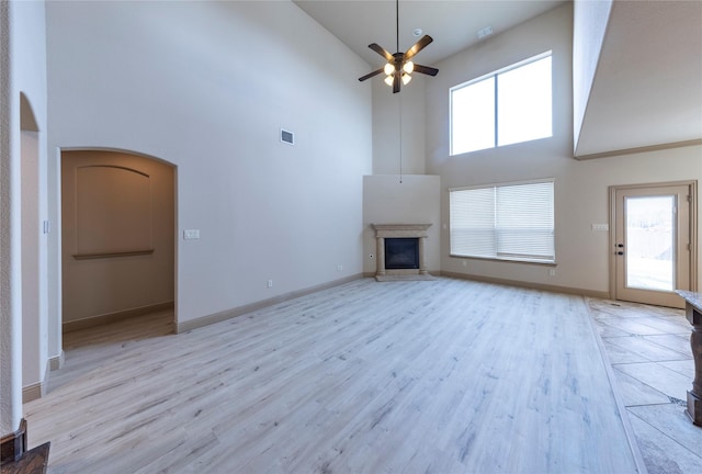 unfurnished living room featuring a wealth of natural light, a fireplace, and light hardwood / wood-style floors