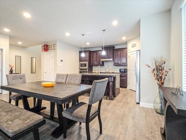 dining area featuring light wood finished floors, baseboards, and recessed lighting