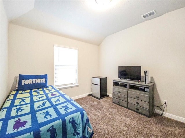 carpeted bedroom with lofted ceiling, fridge, baseboards, and visible vents