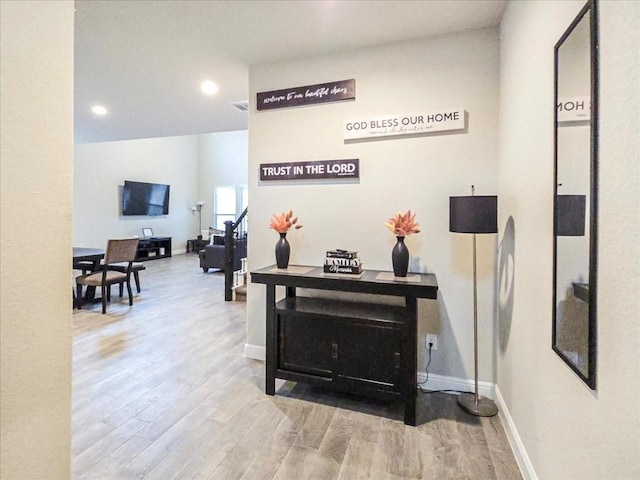 hall with baseboards, wood finished floors, and recessed lighting