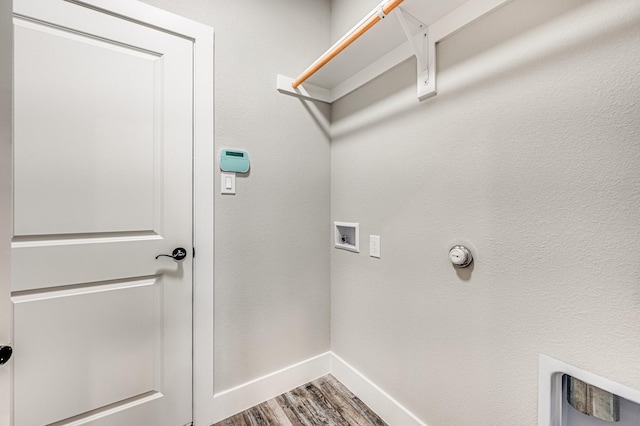 laundry area featuring laundry area, wood finished floors, hookup for a washing machine, and baseboards