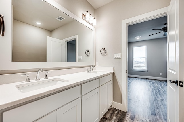 full bath with wood finished floors, visible vents, a sink, and double vanity