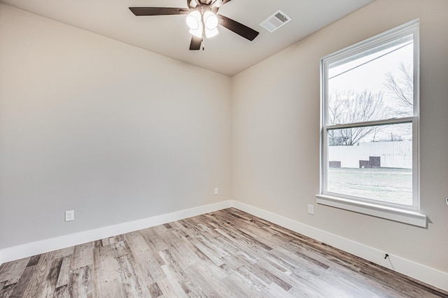 unfurnished room featuring a ceiling fan, light wood-style flooring, visible vents, and baseboards