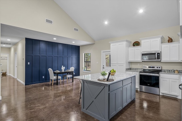 kitchen featuring a center island, stainless steel appliances, visible vents, white cabinetry, and concrete floors