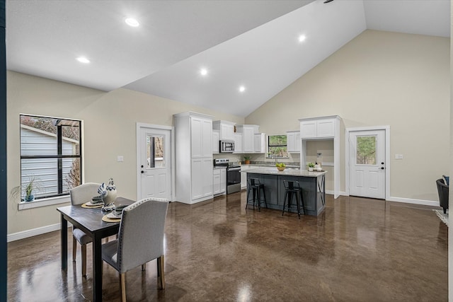 dining area featuring high vaulted ceiling, baseboards, concrete flooring, and recessed lighting