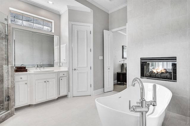 bathroom with a tile fireplace, crown molding, independent shower and bath, and vanity