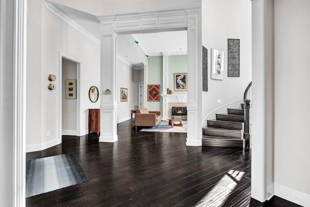 foyer with decorative columns, wood-type flooring, and crown molding