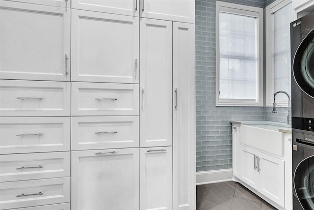 interior space featuring tile walls, vanity, tile patterned floors, and stacked washer / dryer