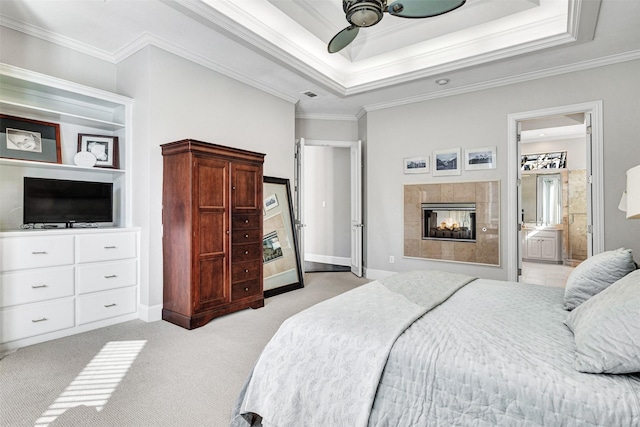 bedroom with light colored carpet, ornamental molding, a raised ceiling, ceiling fan, and a fireplace