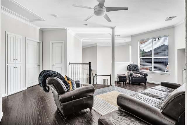 living room featuring dark wood-type flooring, ceiling fan, ornamental molding, and ornate columns