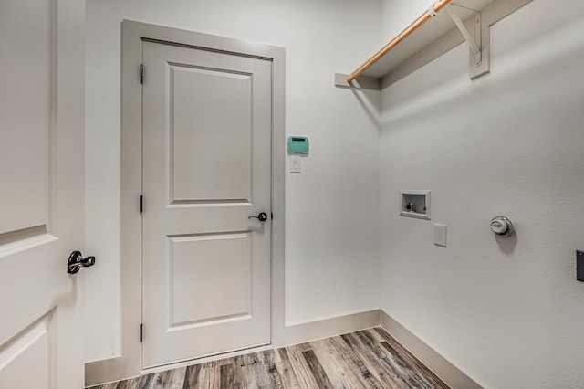 clothes washing area featuring hookup for a washing machine, laundry area, baseboards, and wood finished floors