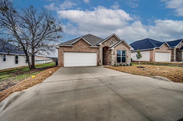 view of front facade featuring driveway, a shingled roof, an attached garage, and brick siding