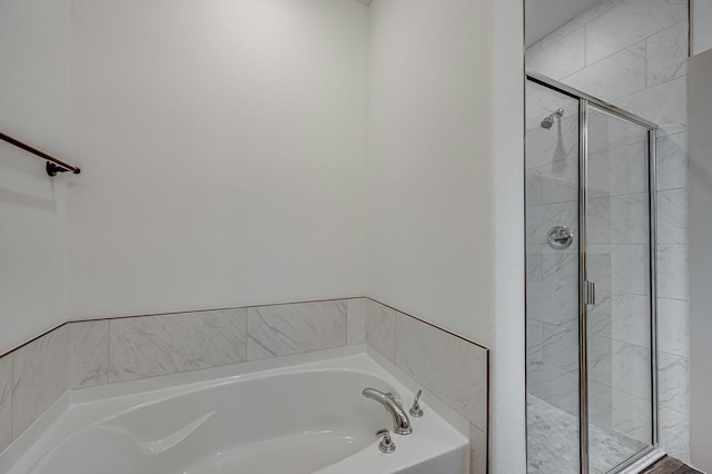 bathroom featuring a garden tub and a shower stall