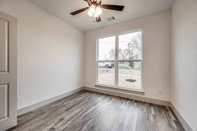 unfurnished room with a healthy amount of sunlight, visible vents, and wood finished floors