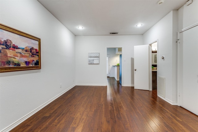 empty room with dark hardwood / wood-style flooring