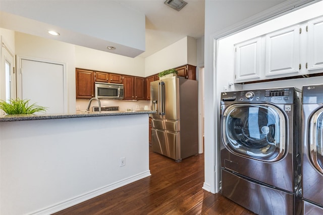 washroom with dark hardwood / wood-style flooring, sink, and washer and dryer