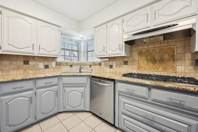 kitchen featuring sink, stainless steel appliances, white cabinets, and light tile patterned flooring