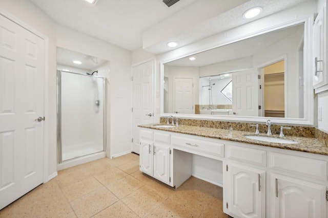 bathroom featuring vanity and a shower with shower door