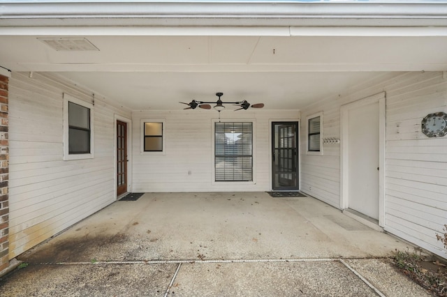 view of exterior entry featuring ceiling fan and a patio area