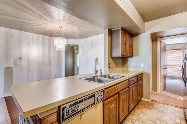 kitchen featuring sink, kitchen peninsula, dishwashing machine, and decorative light fixtures