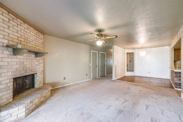 unfurnished living room featuring a brick fireplace, light colored carpet, and ceiling fan