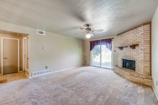 unfurnished living room with a brick fireplace, light carpet, a textured ceiling, and ceiling fan