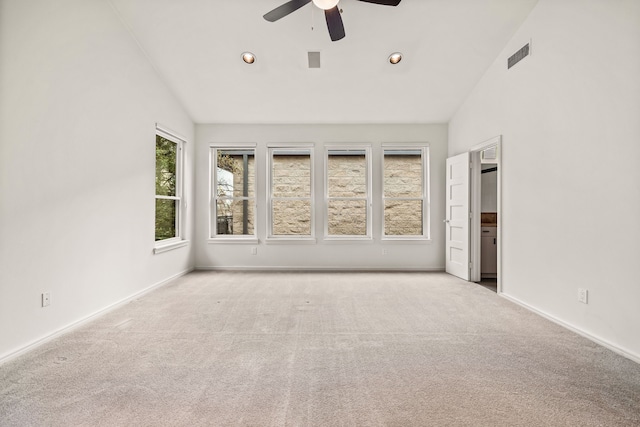 spare room featuring ceiling fan, light carpet, and high vaulted ceiling