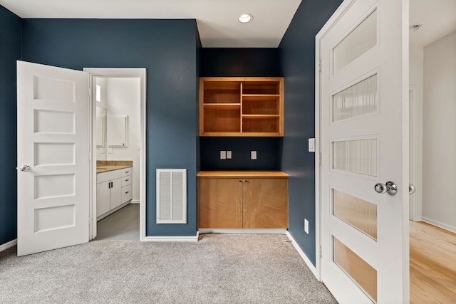 interior space with light colored carpet and ensuite bathroom