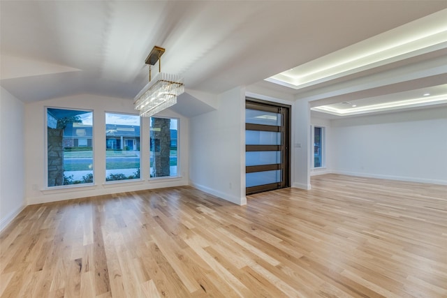 additional living space with vaulted ceiling, light hardwood / wood-style flooring, and a notable chandelier