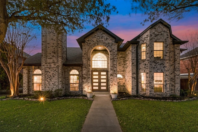 view of front of house with a yard and french doors