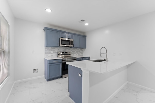 kitchen featuring marble finish floor, a sink, tasteful backsplash, appliances with stainless steel finishes, and baseboards