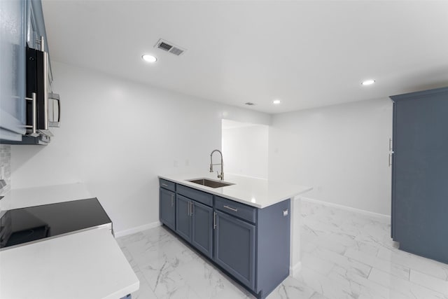 kitchen with visible vents, baseboards, a peninsula, marble finish floor, and a sink