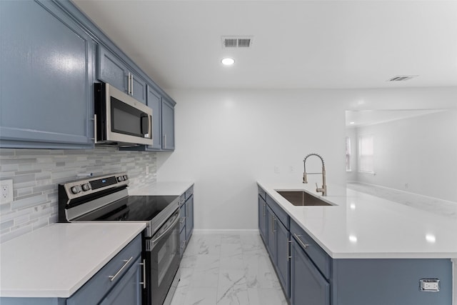 kitchen with visible vents, a peninsula, a sink, stainless steel appliances, and marble finish floor