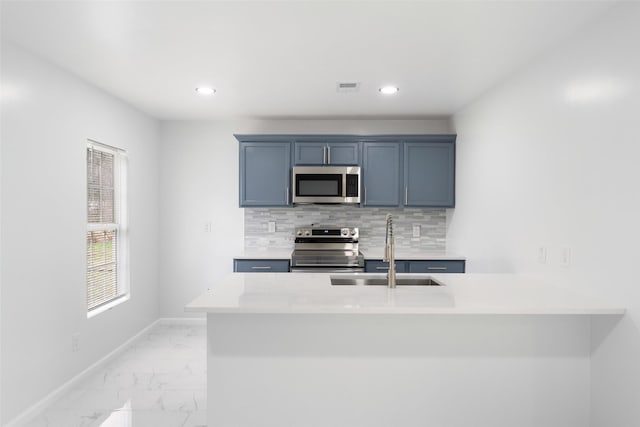 kitchen featuring visible vents, a sink, stainless steel appliances, marble finish floor, and backsplash