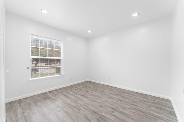 spare room with recessed lighting, baseboards, and wood finished floors